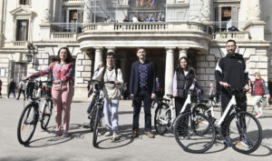 El vicealcalde y concejal de ecología urbana, Sergi Campillo, realiza la entrega de bicicletas eléctricas a las personas ganadoras del sorteo de 'Ara pots apujar el reciclatge'.